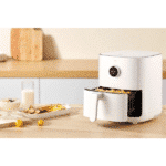 Xiaomi Smart Air Fryer with an open basket filled with cooked food in a modern kitchen setting